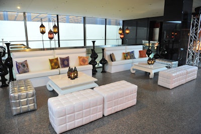 Moroccan-style cushions and oversize vases accented white furniture, from Furnishings by Corey, in the reception space.