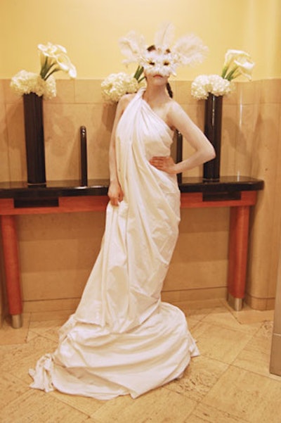 A masked model draped in white fabric stood at the top of the stairway leading to the party space on the trading floor.