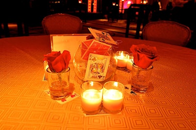 Centerpieces, by Mpire Events, included red roses, votives, and playing cards.