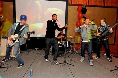 The Goonies provided live entertainment, with a screen showing a montage of event photos behind them.