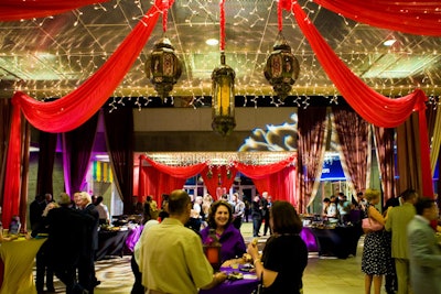 Red, purple, and gold fabrics, Arabian lanterns, and an illuminated replica of a henna tattoo created an exotic atmosphere in the science museum's grand lobby.