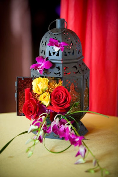 Conceptbait created centerpieces using Middle Eastern lanterns filled with dendrobium orchids, mums, yellow gold-strike roses, and red freedom roses.