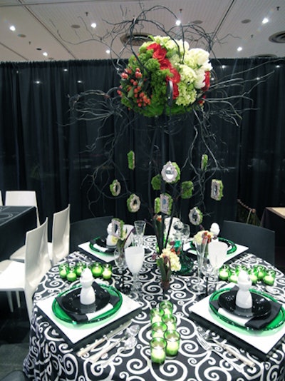 The winning design, by Fourth Wall Events, was a gothic spin on Christmas with green and black accents and mirrored moss-covered ornaments hanging from a round centerpiece of flowers and branches.