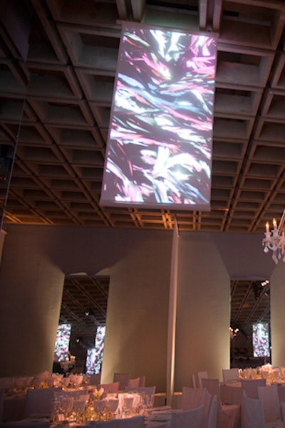 Flanked by long, draped curtains, floor-to-ceiling mirrors added texture and color to the walls by reflecting the video from the projection screens.