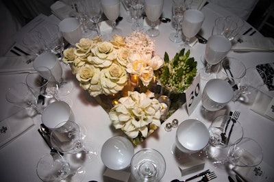 In keeping with the dinner's all-white decor, diverse groupings of more than a dozen types of flowers, including French tulips, hydrangeas, hyacinth, gardenias, tuberose, and ranunculus, formed the low centerpieces at each of the 48 tables of 10.