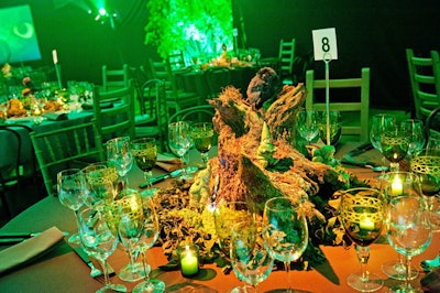 Frank Alexander dressed tables in shades of brown and green and topped each one with alternating arrangements of tree stumps with hidden gnomes and fairies surrounded by flickering candles.