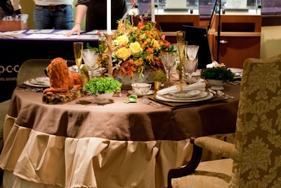 Guests entered Shreve's first-floor main entrance to Darlene Gentle's fall-centric, bird-themed table with an olive green chaise lounge, brown and gold linens, and a yellow floral centerpiece.