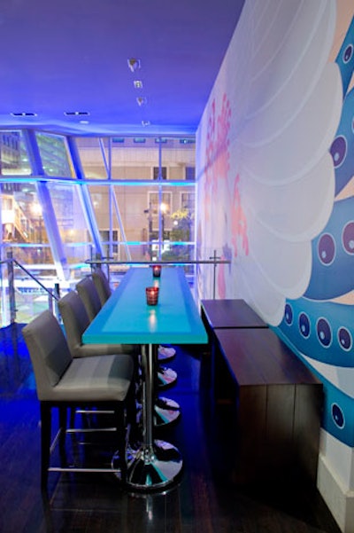 The decor at Phoenix Lounge at the Wit Hotel includes black velvet lounge chairs, leather sofas, and blue resin tables.