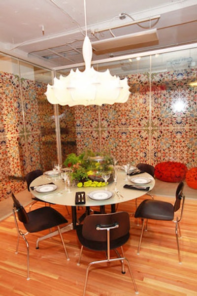 Herman Miller by Gensler surrounded a chandelier with cocoonlike material. A glass wall covered with colorful butterfly designs surrounded the table.