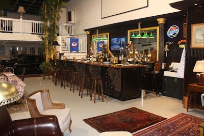 The hand-carved wood bar can seat seven and has a small prep kitchen behind it.