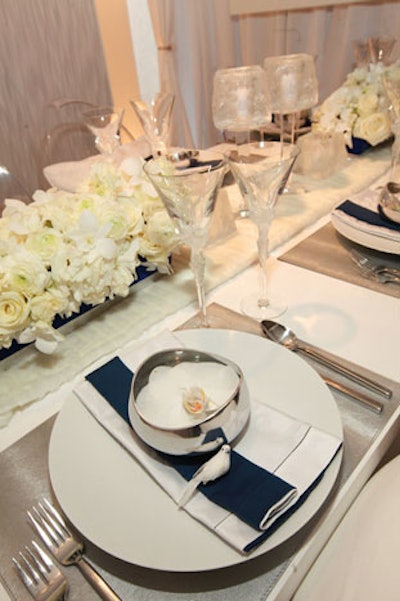 White was a prominent color at several tables, including the one from CS Interiors by Neff of Chicago. Prop birds sat beside bowls of floating flowers at each place setting, and long centerpieces held bunches of white roses.