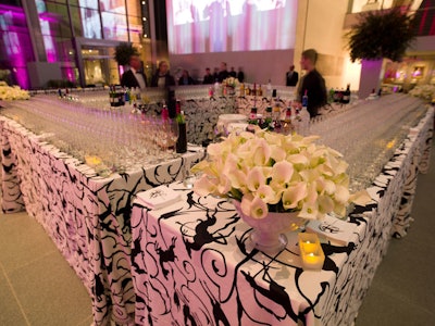 Rows of champagne flutes covered a rectangular bar, where the black-and-white palette was reflected in printed table linens and Winston's white floral arrangements.