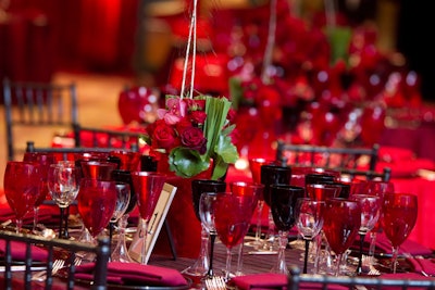 Guests at Knock Out Abuse sat at round tables draped in red linens, anchored by a rose and peacock feather centerpiece