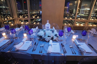 Set in displays of white florals, Absolut Glimmer bottles served as the dinner table centerpieces. Other accessories, including the charger plates, napkin rings, and glassware, matched the blue, white, and silver color scheme.