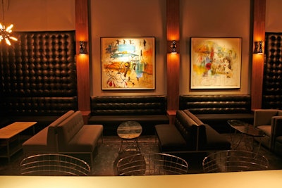 Tufted seating lines the perimeter in the main room.