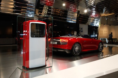 Audi commissioned Munich-based graphic design studio Mirko Borsche to create 'e-den,' a 1,000-square-foot installation that imagines a gasless station in the future where hybrid cars, such as the e-tron Spyder on display, are charged instead of fueled. A 1950s gas pump is encased in glass to recall an oil-dependent era. A pop-up café from Touch Catering serves organic snacks from behind the installation.