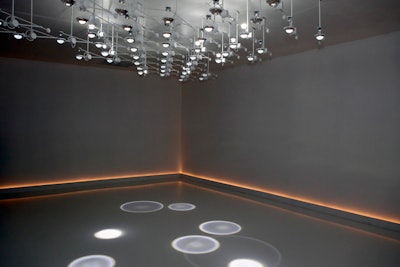 Sponsor Swarovski hired designer Sebastian Noel from Troika to create 'Falling Light,' a 600-square-foot installation using 50 suspended mechanical devices—each incorporating a custom-cut Swarovski crystal optical lens, a computer programmed motor, and a white LED—to create floor-strewn droplets.