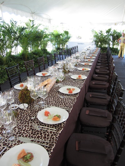 Sotheby's safari-themed table design included full-width runners with different animal prints for each table and white orchid centerpieces embellished with moss. Short bamboo and pine branches added height and texture.