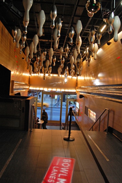 Inside the entrance area, a chandelier of bowling-pin-shaped fixtures hangs overhead.