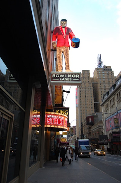 A 20-foot-tall vintage-style neon sign marks the entrance to the venue, complementing the other bright signs in Times Square.