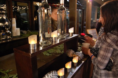 The few decor elements for the event included votive candles, posters of the company's different spirits brands, pinecones, and fir branches.