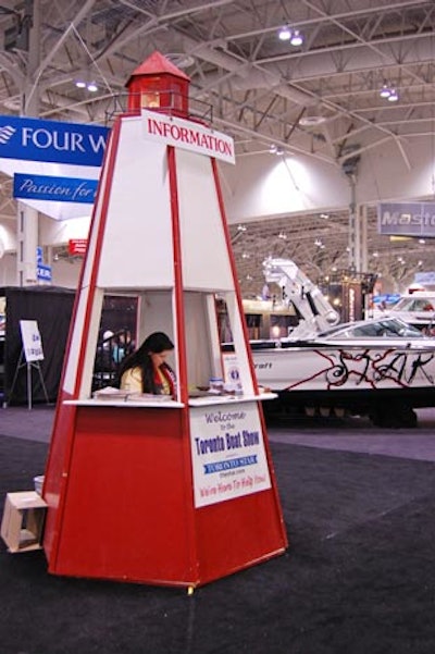 Greeters at the Toronto International Boat Show offer visitor guides and information to guests at booths designed to look like lighthouses.