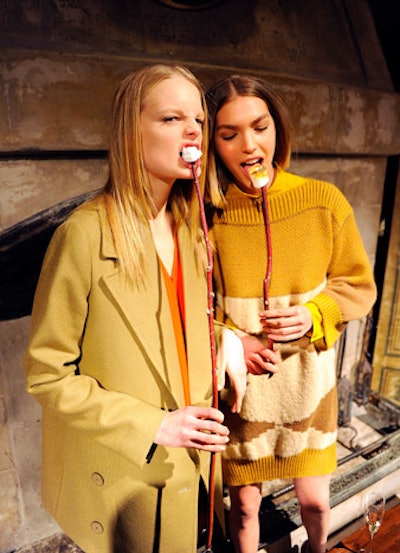 Clad in McCartney's pre-fall 2011 designs, models interacted with guests while doing things like roasting marshmallows, playing board games, reading English books, and listening to a record player.