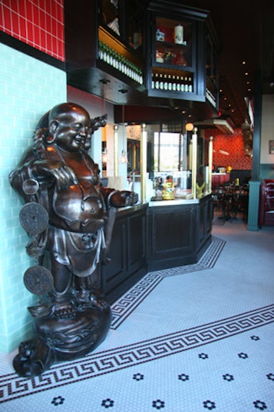 The decor inside Miss Yip consists of Buddha statues, glass jars with Chinese spices, ceramics, marbles, birdcages, Chinoiserie wallpaper, and other decorative elements.