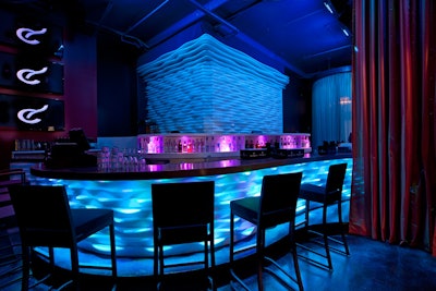 Behind the main bar is a small elevated stage that can be used for presentations or entertainment.