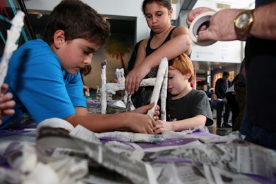 Parents and children worked together to create a table made only of newspaper and tape that could support at least 50 pounds.