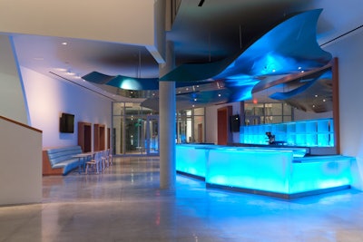 Cool blue lighting and fabric are used throughout the 100,000-square-foot facility, including in the atrium bar.