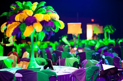Corinthian Events brought in jester-hat chair covers and tall, feather-filled centerpieces to add color to tabletops and match the scale of the room.