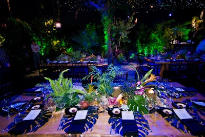 Faux monstera leaves served as place mats on the hand-carved oak tables.