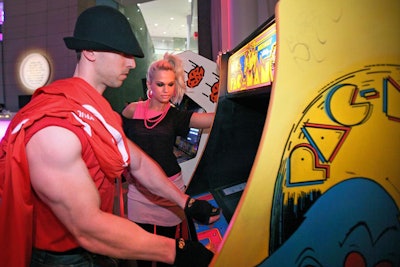 Models dressed in '80s attire directed guests to a corner of the atrium set up with arcade games.