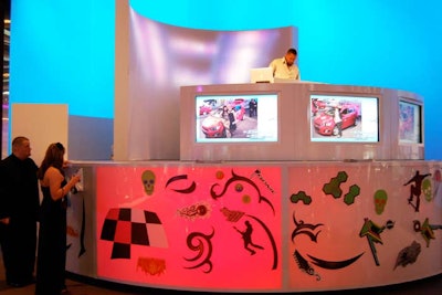 A tall DJ booth stood in the display area for the Chevrolet Sonic. Decals lined the base of the booth, and guests could decorate the Sonic models with sticky images of their choosing. Visitors could then have their photos snapped with their decorated cars, and receive the photos via email.