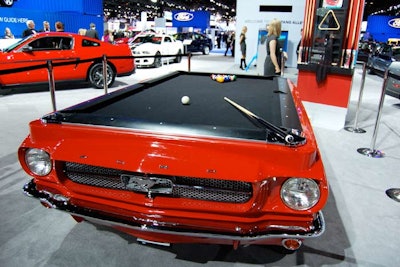 In Ford's display area, a vintage Mustang had a pool table built onto its base. Triangles and cues hung on a nearby rack, and guests could play pool at will.