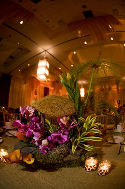 Conceptbait created miniature thatched huts to anchor the centerpieces, which also included a variety of vibrant flowers and candleholders wrapped in animal print fabric.