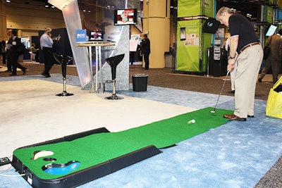 At the S.C.C. Soft Computer booth, attendees could win pens, golf towels, and golf balls by hitting a hole-in-one on a small putting green.