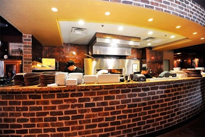 The open kitchen is anchored by a large stone hearth oven used to prepare City Fire's flat breads.