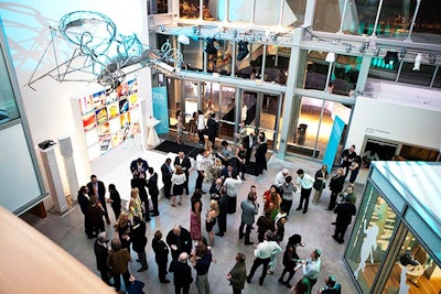 Guests mingled in front of a stage and wall displaying Design Award winners.