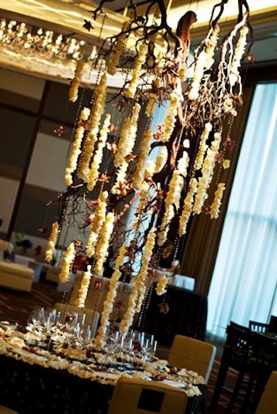 Mandarin Oriental's table, known as 'Hanging Chandelier,' used an array of browns and creams to complement the hotel's ballroom. It included a sustainable hanging centerpiece of branches and roses. The flowers from the table accentuated the height of the room without interfering with guests' conversation, and used the hotel's standard linens and show plates.