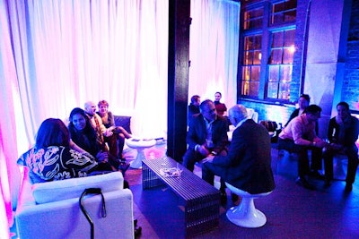 The V.I.P. lounge, designed by PBD Events, included low seating, white sheer draping, and blue up-lighting.
