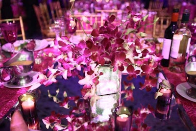 Floral designer Jennifer Dolan created multiple centerpieces for the dinner tables, like purple orchids in stacked square glass vases.