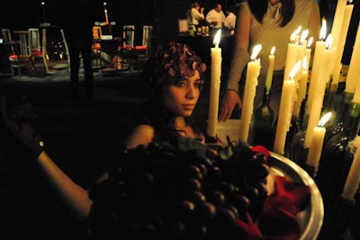 A performer lay in a bathtub covered with a pool of candlelit wine bottles. Two trays at the side of the tub held hors d'oeuvres such as deviled eggs.