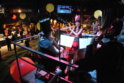 Wearing festive hats, a trio of musicians serenaded guests from a balcony above the main space.