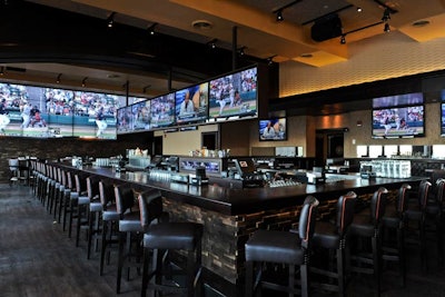 A rectangular bar anchors the space and has dark brown leather seating with orange trim.
