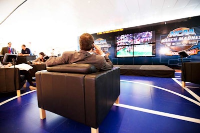 Marked by basketball-court-style flooring, the bracket lounge included a seated section for the public to watch the tournament on four large-screen TVs. IPads attached to comfy armchairs provided access to the N.C.A.A.'s March Madness on Demand app.