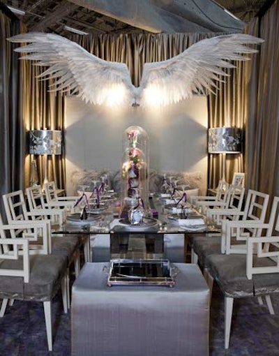 Jeffrey Brooks Interior Design created an ethereal setting with an oversize pair of feathered wings, silvery tabletop accessories, and shiny fabrics on seat covers and draping.