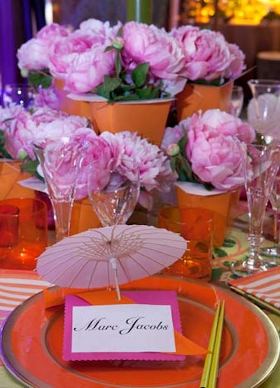 Fabric manufacturer Scalamandré created a preppy setting, complete with parasols and brightly patterned linens and rugs. The fun (and frugal) centerpiece was fashioned out of silk peonies and orange takeout containers.