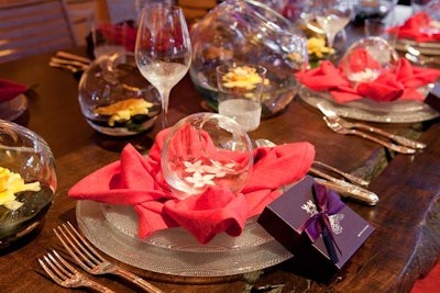 For New York Design Center's table, Coffinier Ku Design folded rose-hued napkins into flowers and topped each one with a flower- and water-filled glass bowl.